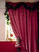 Vorhang in hellem Purpur mit Weihnachtsgirlande