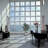 Eine Halle mit Klavier und Panoramablick auf das Meer