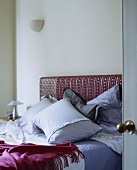Ein Bett mit Kissen und einem pinkfarbenen Cashmere-Überwurf