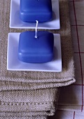 Zwei blaue Kerzen auf weissen Kerzenteller aus Keramik