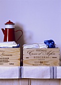 Rote Emaille Kaffeekanne auf alten Weinkisten