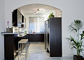 Grauer Fliesenboden in einer modernen schwarz-weißen Küche mit Halogenbeleuchtung