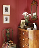 Antike Kommode und Stuhl in der Ecke des roten Wohnzimmers