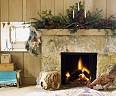 Ein weihnachtlich dekorierter Steinkamin mit Feuer