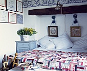 Patchwork-Tagesdecke und weiße Bettwäsche auf dem Bett in einem toskanischen Schlafzimmer