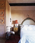 weiße Decken und Kissen auf Einzelbett mit gepolstertem Kopfteil im Spanischen Schlafzimmer mit Rauputzwänden
