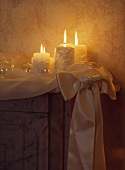 Nahaufnahme brennender Kerzen, die an einer Ecke des Kaminsims aufgestellt sind