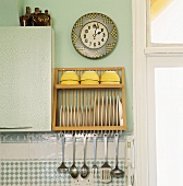 Eine Uhr ist über einen Geschirrhalter und einen darunter liegenden Edelstahl-Besteckset angebracht