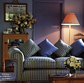 Ein violettes Wohnzimmer, das mit einer gemusterten Couch eingerichtet wurde