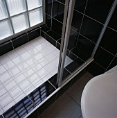 Eine schwarz-weiße Dusche mit Glasschiebetüren