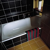 Ein modernes Badezimmer, das mit schwarzen und ockerfarbigen Fliesen ausgelegt wurde