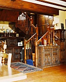 Geschnitzte Holzschränke am Fuß einer verzierten Holztreppe in Landhaus