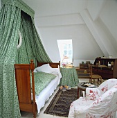 Schlafzimmer im Dachgeschoss mit grünem Vorhang über dem Bett