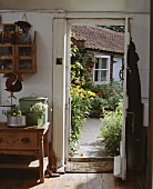 Blick aus dem kleinen Landhaus durch die geöffnete Tür auf den Garten