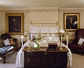 Schlafzimmer mit altes Messingbett, Holztruhe und Ölporträts