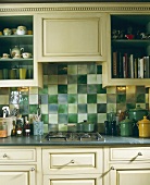 Landhausküche mit antik weissen Schrankfronten und grünen Wandfliesen über Küchenzeile