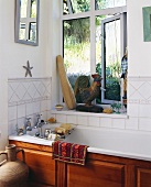 Holzvertäfelte Badewanne und Vintage Armatur in weiss gefliester Badezimmerecke mit Fenster