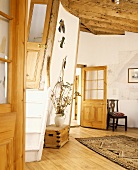 Runder weisser Raum mit Holzbalken und Holztüren in einem ehemaligen Leuchtturm
