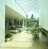 Moderner Wohnraum mit Holzboden und Glasanbau