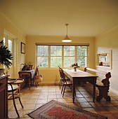 Alter Tisch und Bank aus Kiefernholz in einem Esszimmer mit Terrakotta-Bodenfliesen