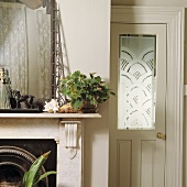 Kaminsims aus Marmor und weiße Tür mit gravierter Glasplatte