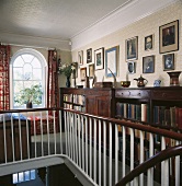 Treppenhaus mit Galerie und antikem halbhohem Bücherregal