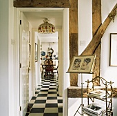 Wand mit Holzkonstruktion und offener Zimmertür mit Blick in Gang auf Schachbrettmusterboden