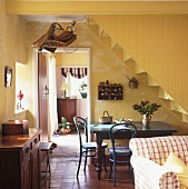 Wohn-Esszimmer mit Tisch und Thonetstühle unter Treppe im Landhausstil
