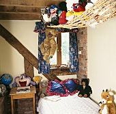 Rustikales Kinderzimmer mit Stofftieren auf Hängematte über Bett