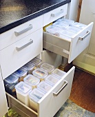 Offene Schubladen eines Küchenunterschrankes mit Aufbewahrungsboxen
