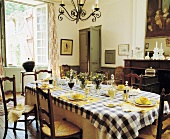 Gedeckter Tisch mit schwarz weiß karierter Tischdecke im traditionellen Esszimmer