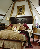 Doppelbett mit holzgeschnitztem Kopfteil im Schlafraum im eleganten Landhausstil