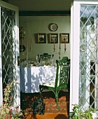 Blick durch offene Terrassentüren aus Glas auf festlich gedecktem Tisch mit Tischdecke und Kandelabern