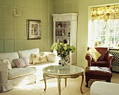Weisses Sofa in lindgrün getäfeltem Wohnzimmer