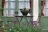 Gartentisch und Stühle vor alten Terrassentüren