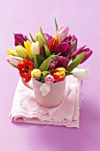 A bunch of colourful tulips in a cup