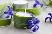 Tealights wrapped with leaves and decorated with hyacinth flowers