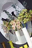 Orchids in vases in front of a round mirror
