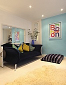 Ein grosser Wandspiegel hinter einem dunkelblauen Sofa in einem Wohnzimmer