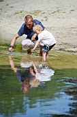 A father and a daughter play in a lake
