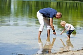 Vater und kleine Tochter spielen im See