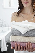 Young woman with a pile of bath towels