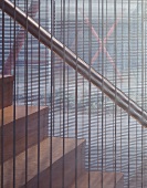 Contemporary staircase with see-through metal grid dividing the staircase from the rest of the room