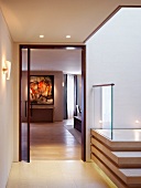 Lobby with contemporary staircase and view through an open door into a living room