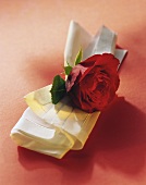 White fabric napkin with red rose