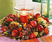 Autumn wreath around glass with red candle