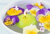 Floating candle and pansies in bowl