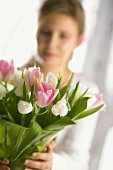 Frau hält Vase mit Tulpenstrauss