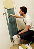 A man painting wood panelling