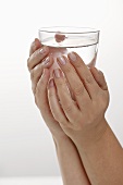 Hands holding a glass of water